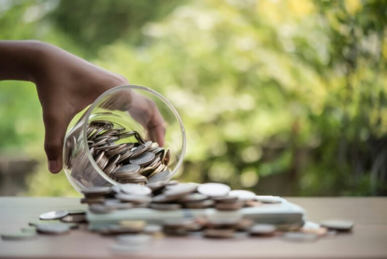 Hand putting coins in jar with money stack step growing growth saving money